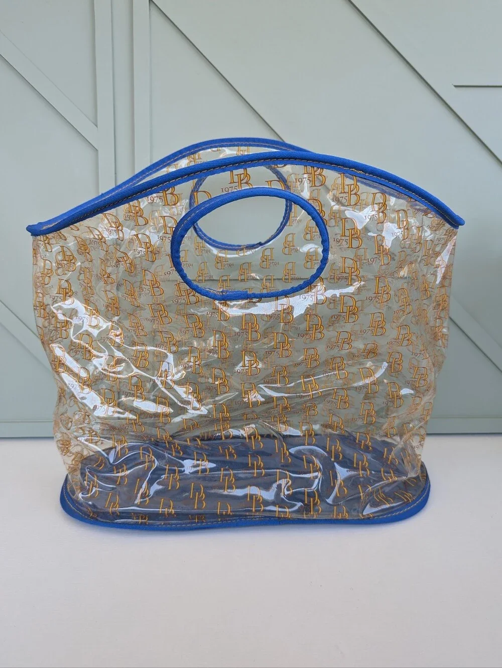 Dooney & Bourke Clear Tote with Blue Trim and Gold Logo Print